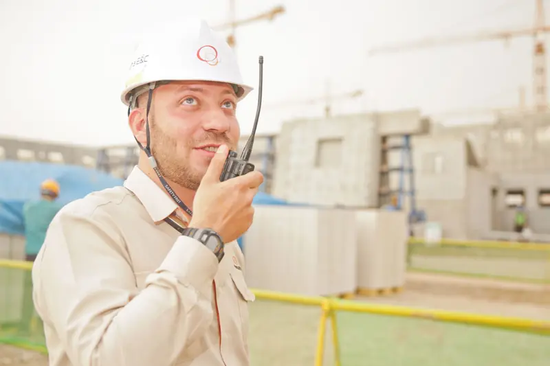 Engineer coordinating work on a project site with a two-way radio