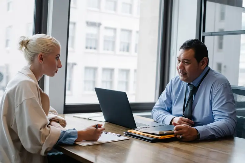 Recruiter interviewing a job candidate across a table
